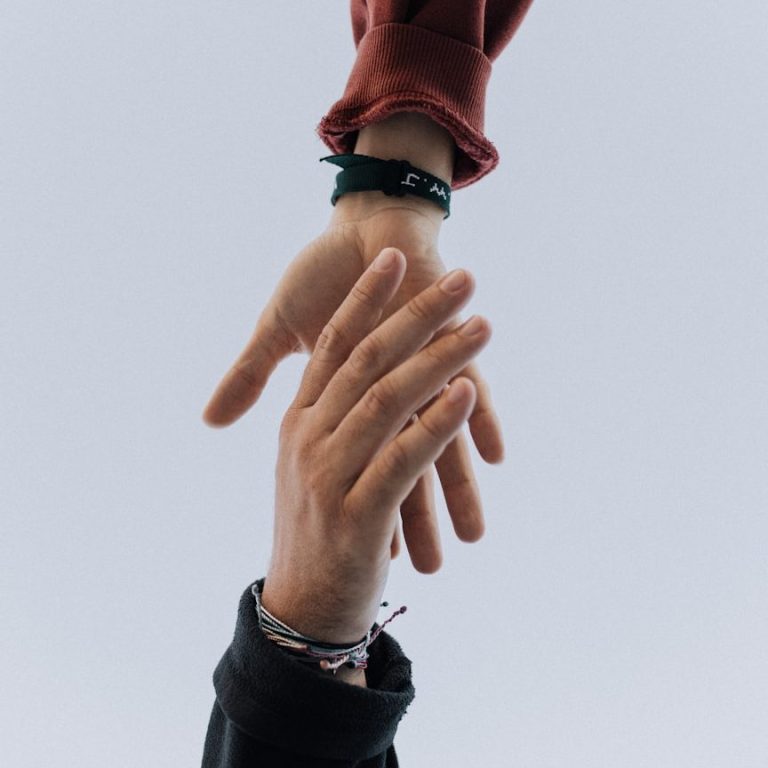 L'entraide dans les équipes de restautration Deux mains se touchent, symbolisant un lien ou une connexion entre deux personnes.