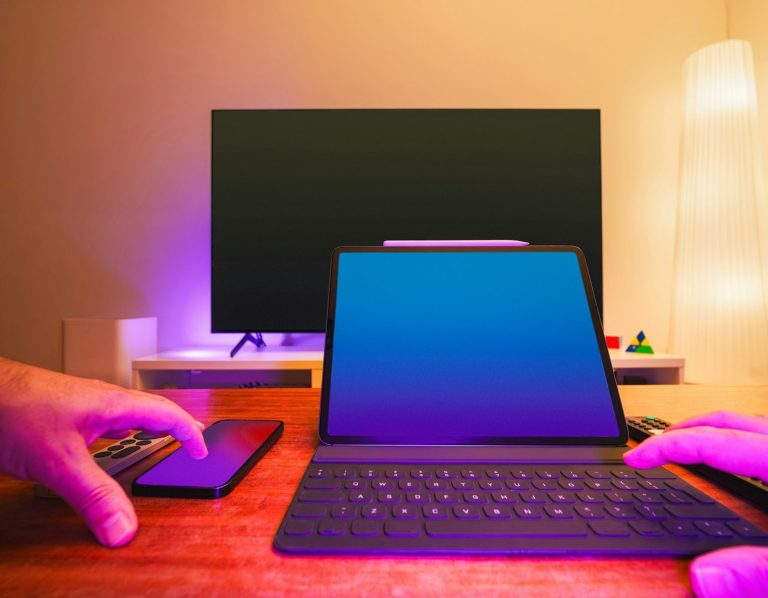 Travail du bureau Deux mains interagissent avec un ordinateur portable et un smartphone sur une table, éclairage moderne.